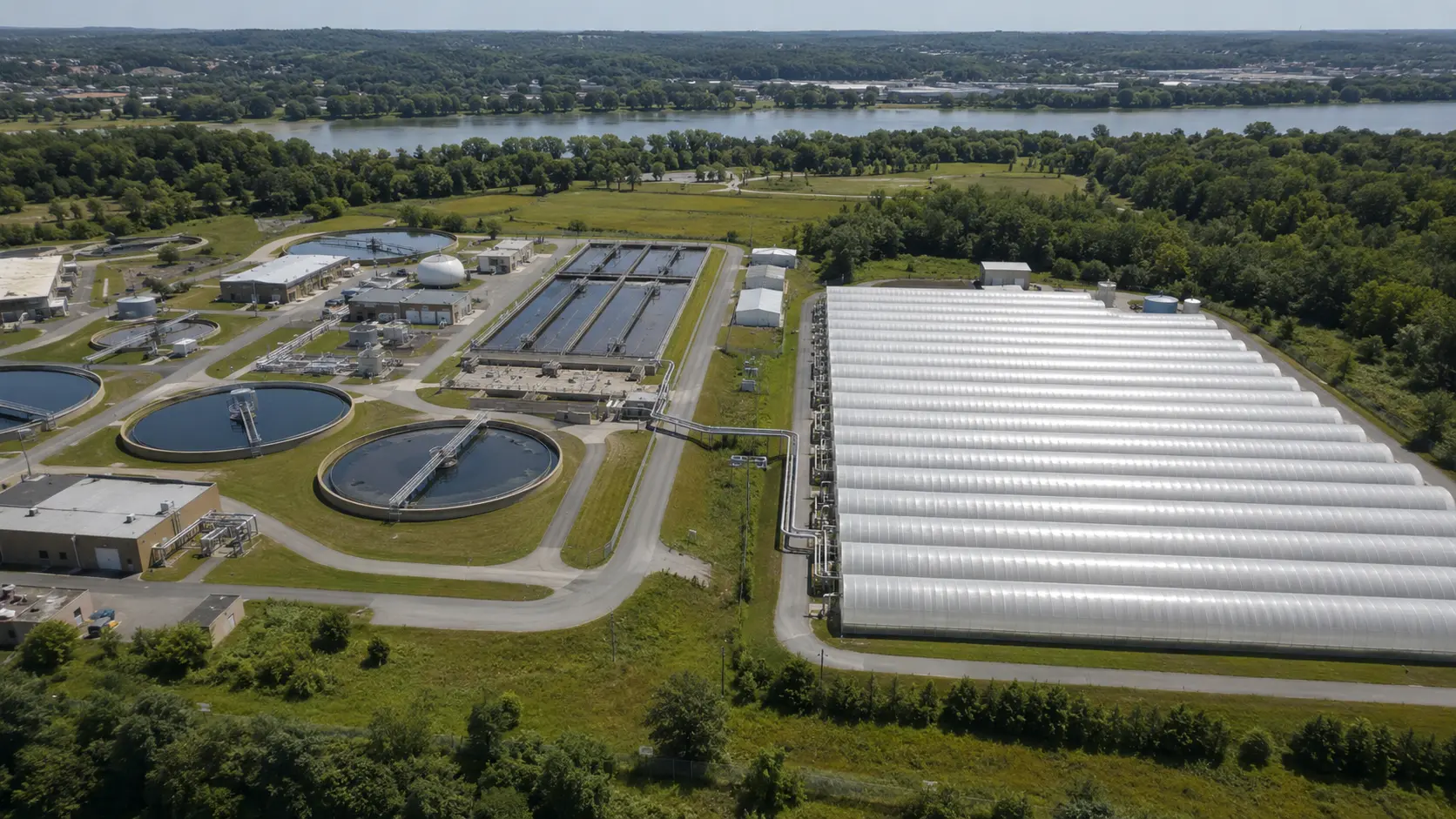 AI-generated conceptual visualization of covered biological infrastructure adjacent to a wastewater-treatment facility